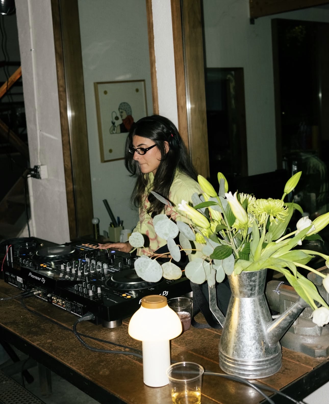 Melody.MP3 mixing on Pioneer decks beside a vase of flowers